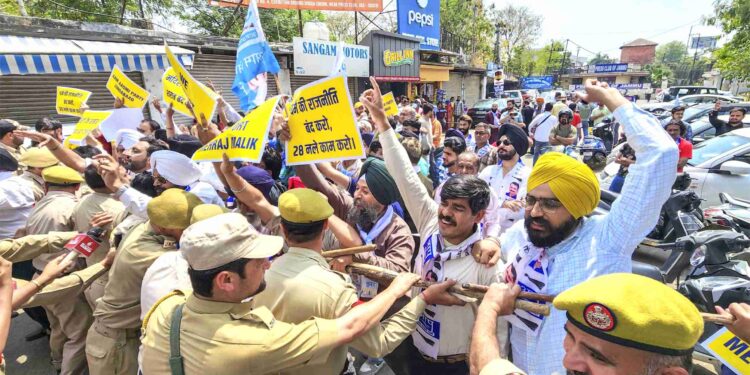 Police stop Aam Aadmi Party supporters during a protest against PDP and BJP, in Jammu.